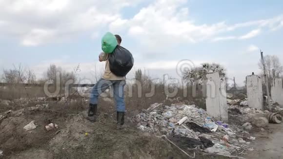 无家可归的人站在垃圾场的垃圾堆里视频的预览图