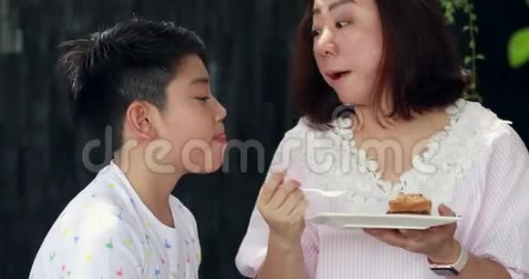 亚洲母亲和他的小儿子一起吃蛋糕视频的预览图
