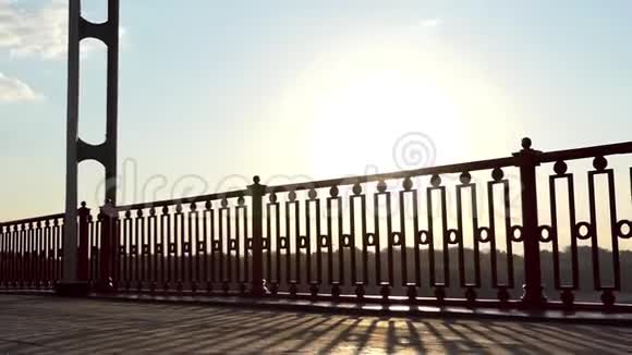 欢乐的人在斯隆莫的日落桥上微笑奔跑跳跃视频的预览图