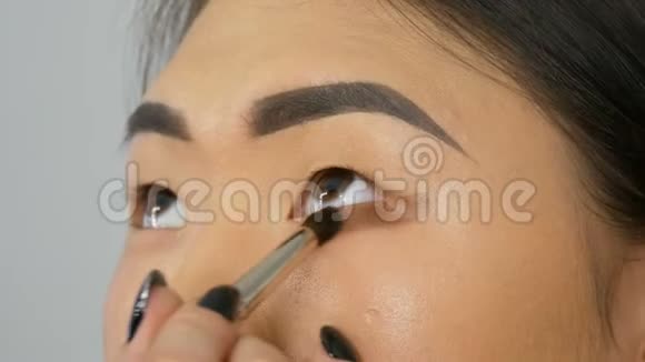 专业化妆师用特殊的画笔为韩国女孩亚洲女性化妆视频的预览图