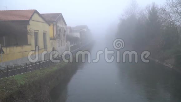 雾天河流水面宁静景象水渠附近人行道视频的预览图