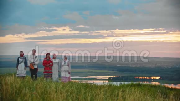 穿着俄罗斯传统民俗服装的人们在田野上行走视频的预览图