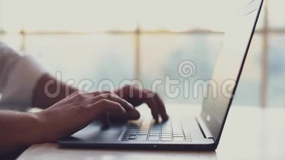 特写男人的手在笔记本电脑键盘上打字视频的预览图