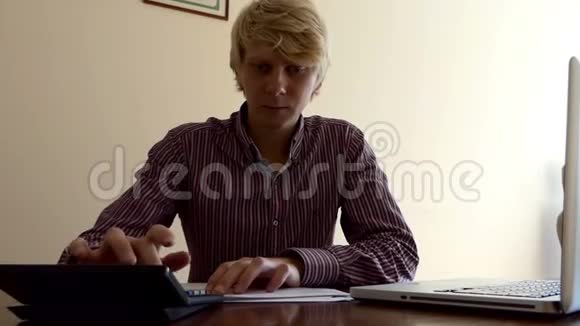 一个年轻人用计算器计算一些东西视频的预览图