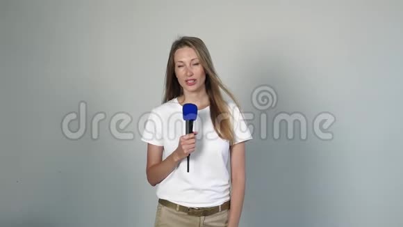 年轻漂亮的女人用麦克风说话视频的预览图