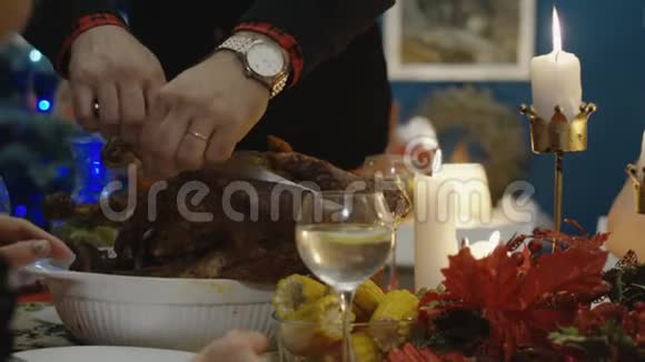 在圣诞晚餐上雕刻火鸡的人视频的预览图