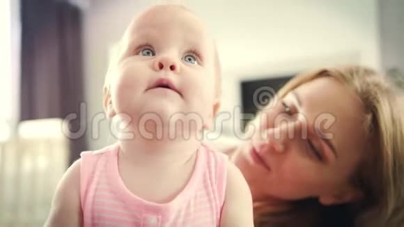 妈妈在亲吻宝宝美丽的母亲亲吻女儿母亲概念视频的预览图