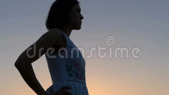 在灿烂的夕阳下一位运动的年轻女子做着空中亲吻的姿势视频的预览图