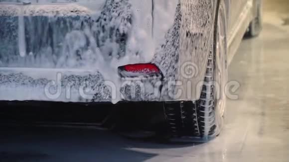 洗车洗车机清洗汽车汽车上覆盖着泡沫特写镜头视频的预览图