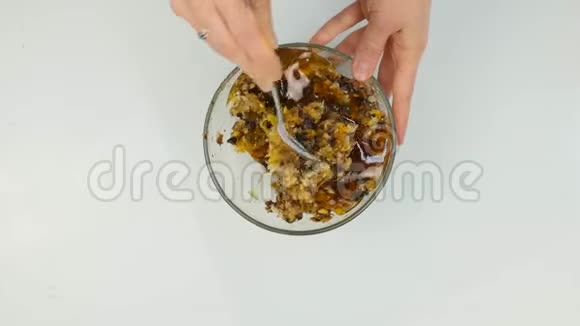 女人在坚果黄油中加入蜂蜜然后把配料混合在碗里4K视频的预览图