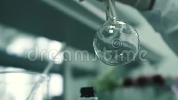 实验室工作人员将化学液体倒入瓶中视频的预览图