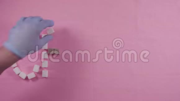 单词龋齿在粉红色背景上内衬精制的糖块龋齿的概念视频的预览图