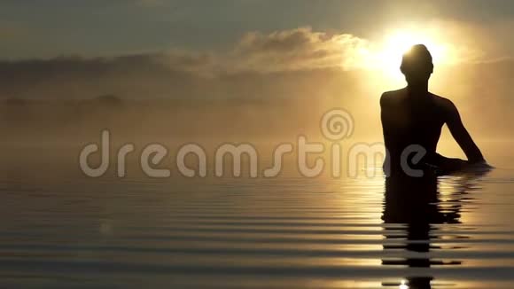 快乐的男人在夕阳西下的湖面上展现出一种爱的姿态视频的预览图