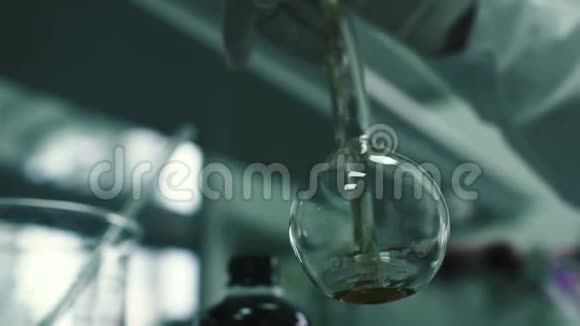 实验室工作人员将化学液体倒入瓶中视频的预览图