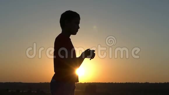 日落时分小男孩在湖岸变换手腕视频的预览图