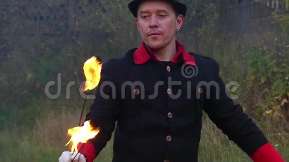 魔术师在森林里缓慢地吹着金属风扇把火放下视频的预览图
