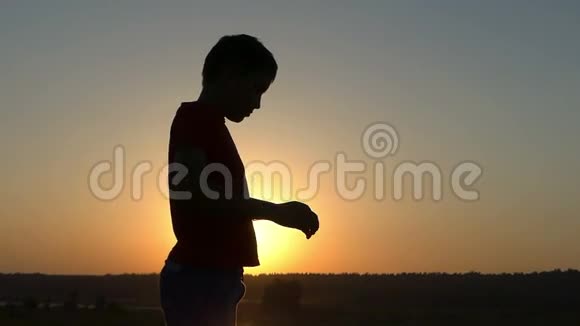 日落时在湖岸进行的男孩手臂背部训练视频的预览图