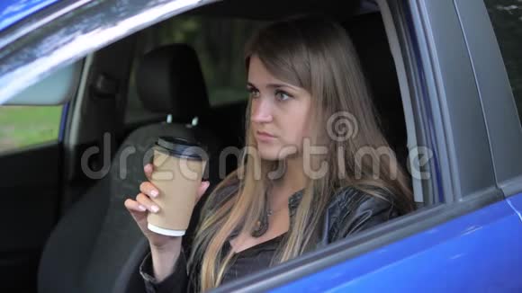 坐在车里喝咖啡的年轻美女视频的预览图