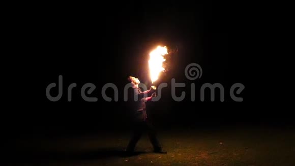 年轻的魔术师吹着他的两把火把晚上在懒洋洋地视频的预览图