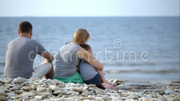 家人坐在海滩上视频的预览图