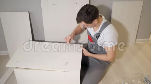 年轻的修理工在家里组装新桌子视频的预览图