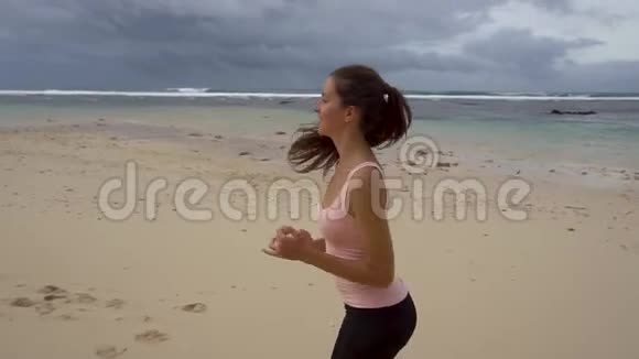 身材苗条的年轻女子在日出时在海上从事体操视频的预览图