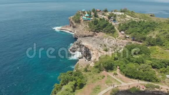 在印度尼西亚的努沙佩尼达的破滩俯瞰岩石海岸和海湾空中观景视频的预览图