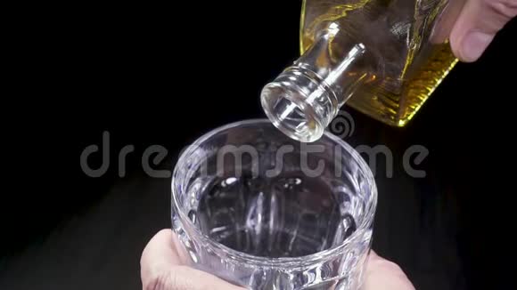 一个男人把威士忌倒在杯子里视频的预览图
