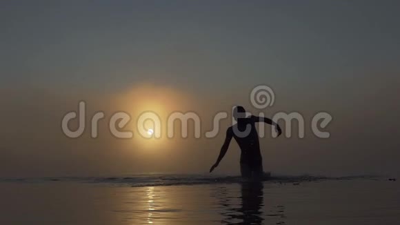 夕阳西下年轻人从雾蒙蒙的湖面上奔跑视频的预览图