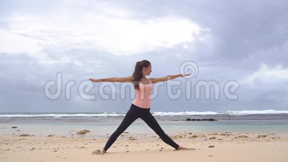 做瑜伽的女人延伸三角形姿态asana海洋背景视频的预览图