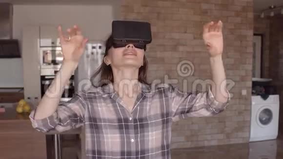 漂亮的黑发女孩在家里使用她的手机VR耳机虚拟现实眼镜在行动4克斯泰德姆视频的预览图