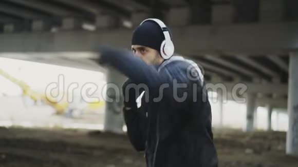 斯泰迪卡姆拍摄的运动男拳击手戴着耳机在城市户外运动冬天视频的预览图