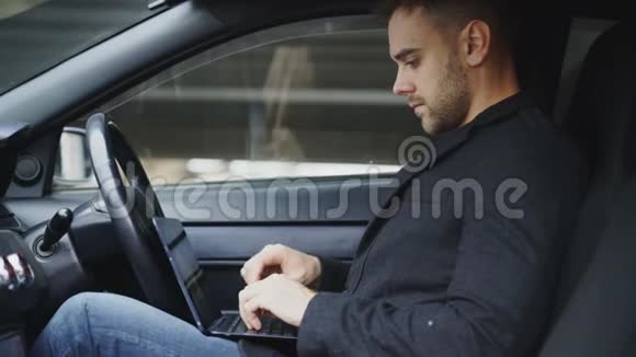 有魅力的年轻人在户外坐在车里使用平板电脑视频的预览图