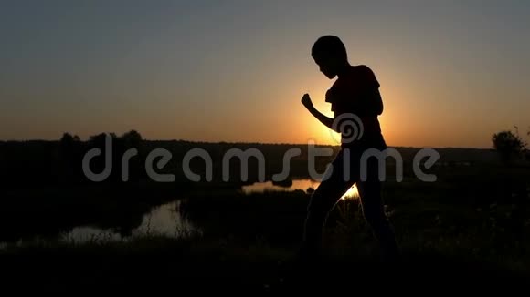 秋季日落时小男孩火车在湖岸吹拳聚焦视频的预览图