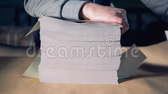 一个人正在把一捆杂志包装成手工包装纸视频的预览图