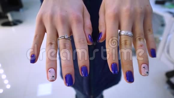 手特写修指甲蓝色指甲油一个小女孩在镜头上展示她的美甲这是为她做的视频的预览图