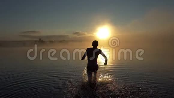 快乐的人在夕阳西下的一个湖里跑来跑去视频的预览图
