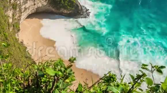 印度尼西亚巴厘NusaPenida岛的Kelingking海滩上带波浪和人的Ariel时移景色视频的预览图