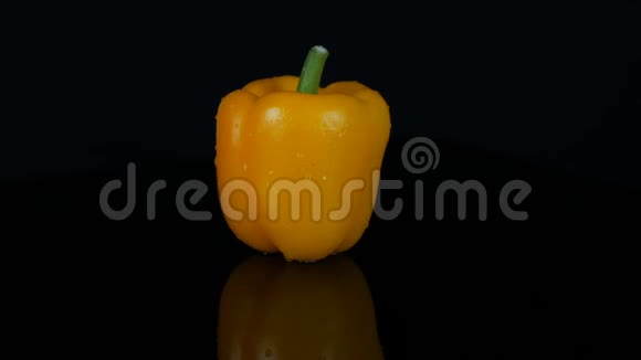 黑色背景和镜面上的鲜甜黄椒辣椒视频的预览图