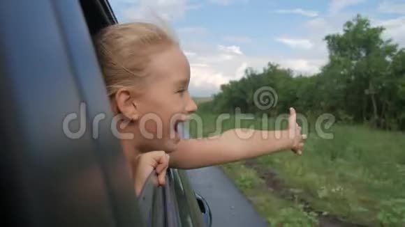 快乐的少女斜靠在车窗外假期概念视频的预览图