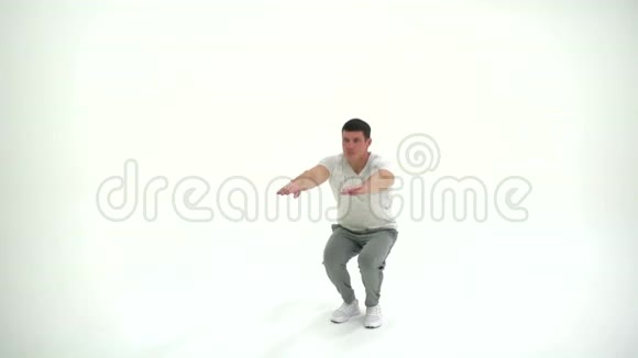 健身运动员男子在4K白色背景的工作室进行蹲式锻炼视频的预览图