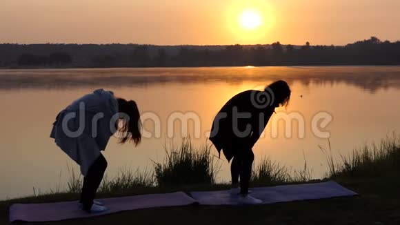 两位年轻女性在夕阳下的瑜伽练习视频的预览图