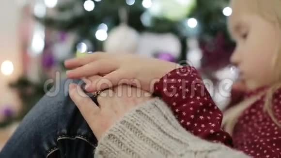 带戒指的老手金发小女孩把手放在祖母手上视频的预览图