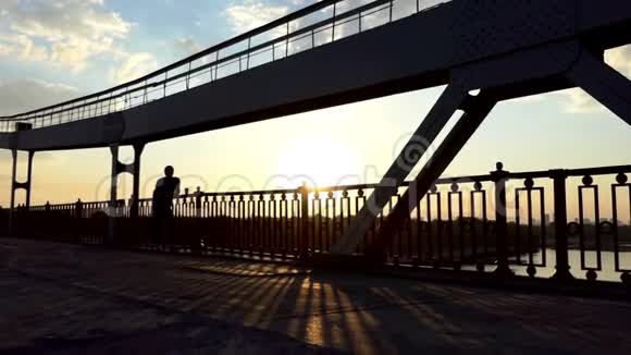 年轻人放松喝咖啡在斯隆莫的桥上享受日落视频的预览图