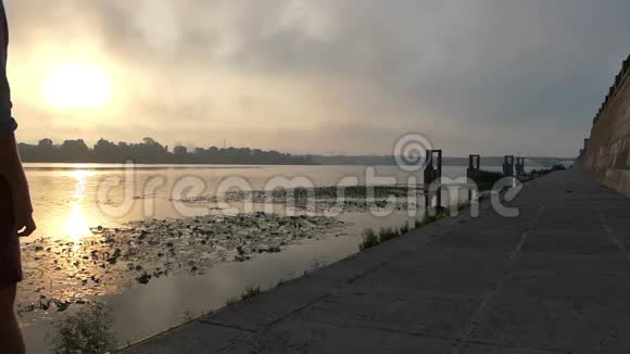 微笑的年轻人在斯隆莫的夕阳下漫步在河岸视频的预览图