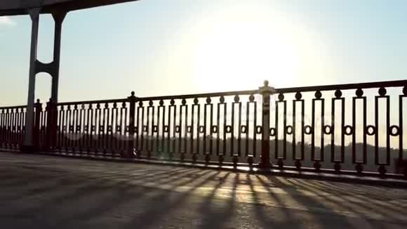 在斯隆摩灿烂的夕阳下年轻人沿着现代的桥梁奔跑视频的预览图