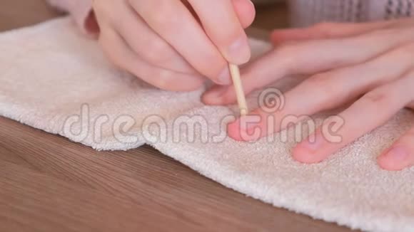女性清洁多余的指甲波兰使用木橙棒修指甲视频的预览图