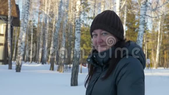 肖像成年妇女在冬季村舍附近散步视频的预览图