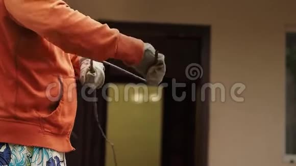 戴工作手套的人顺时针旋转一根金属电缆视频的预览图