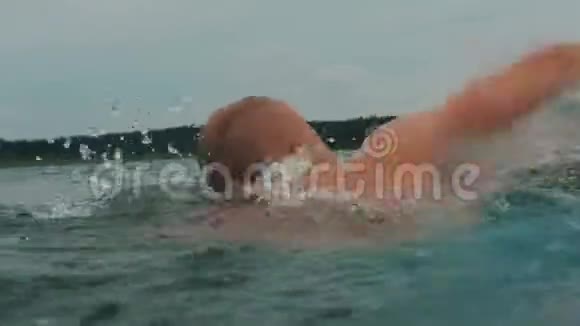 4k的肌肉男在湖边游泳后景视频的预览图